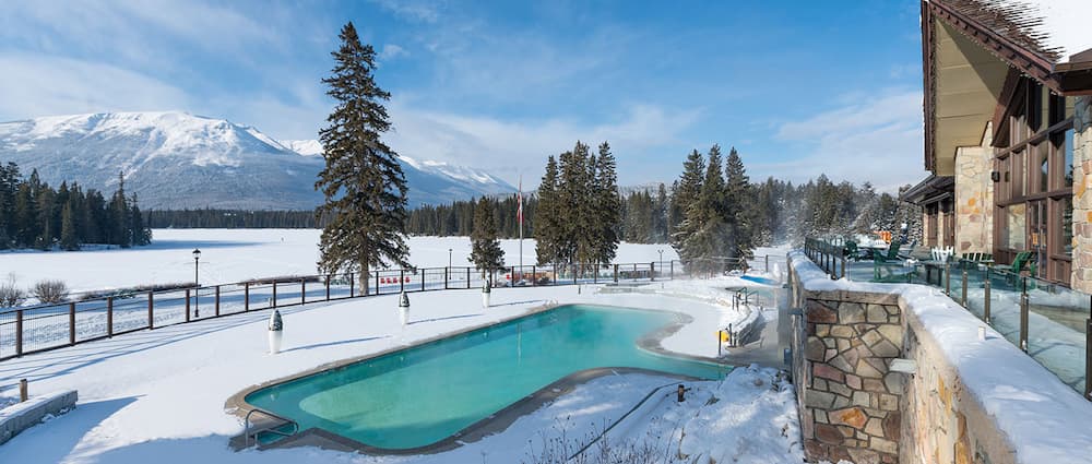 An outdoor swimming pool with a mountain view at Jasper Park Lodge