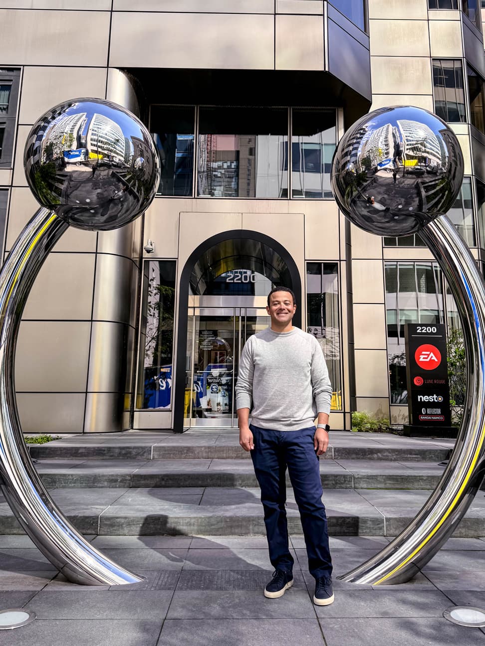 Liam Mayes standing in front of an art sculpture