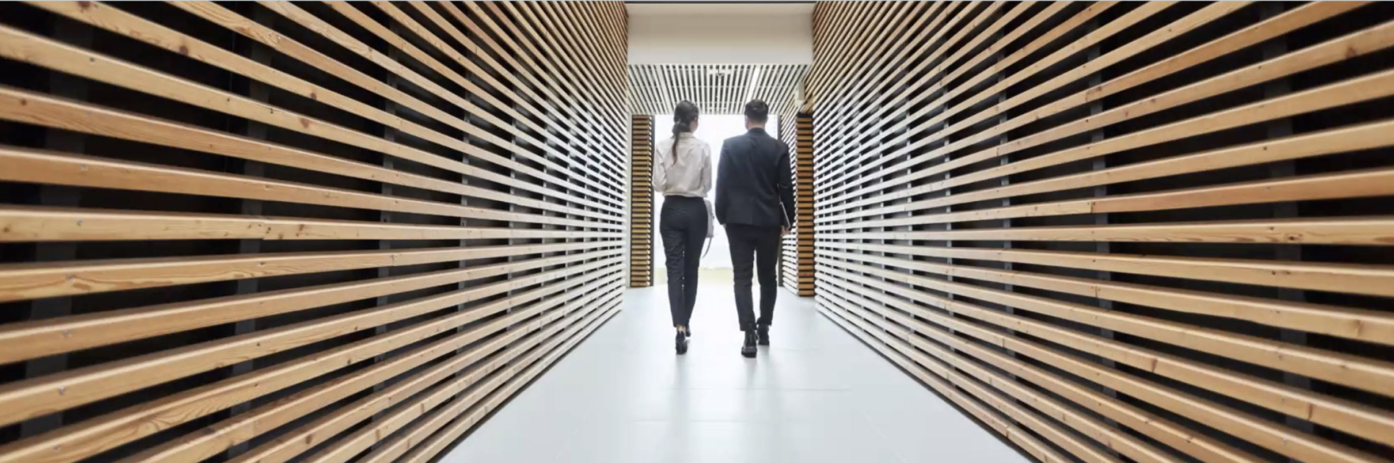 two business people walking down office hallway