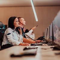 People working at a control center, one on the phone, looking at monitors.