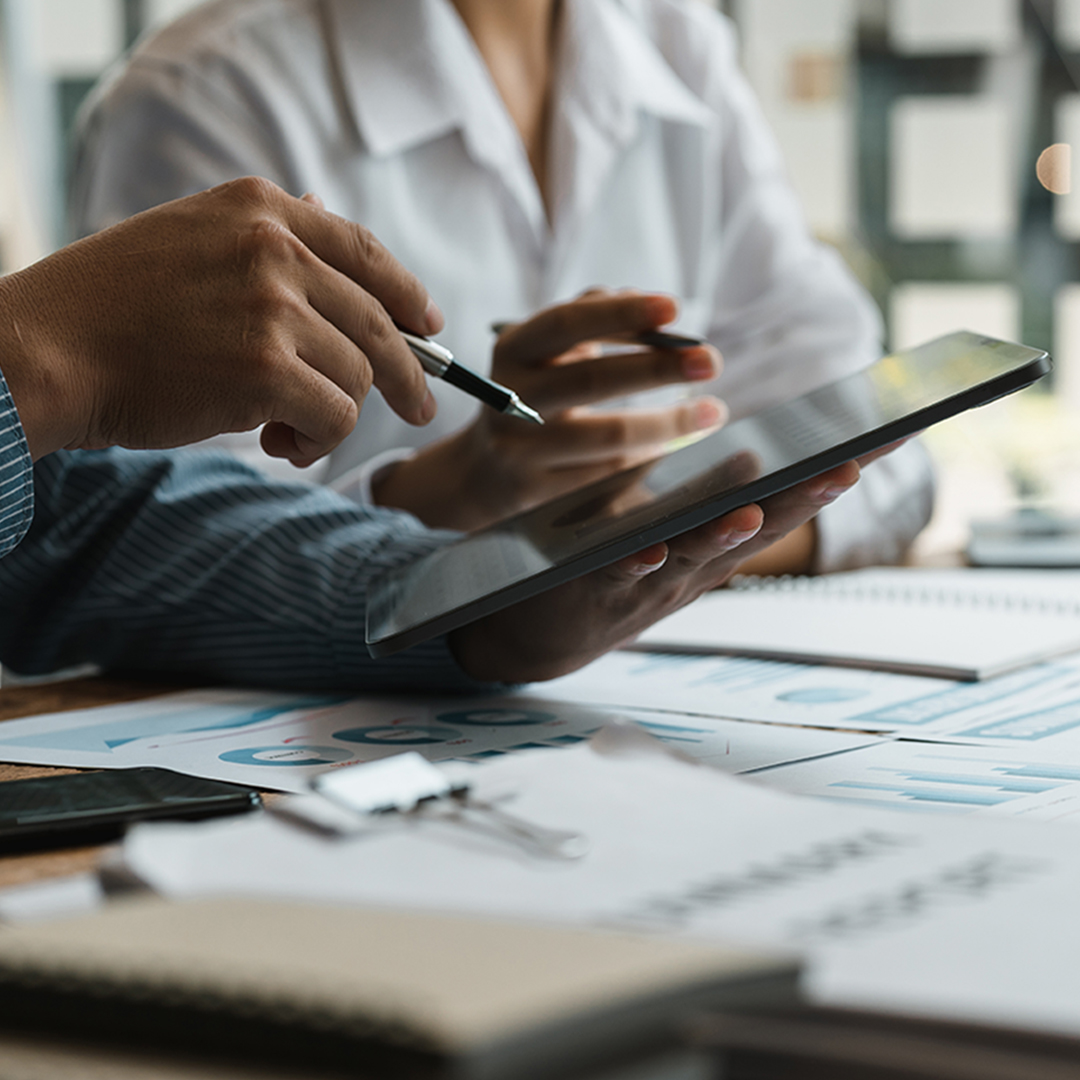 two investors review information on a tablet