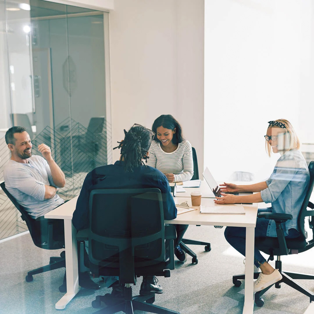 Team having casual meeting around white desk in bright modern office space