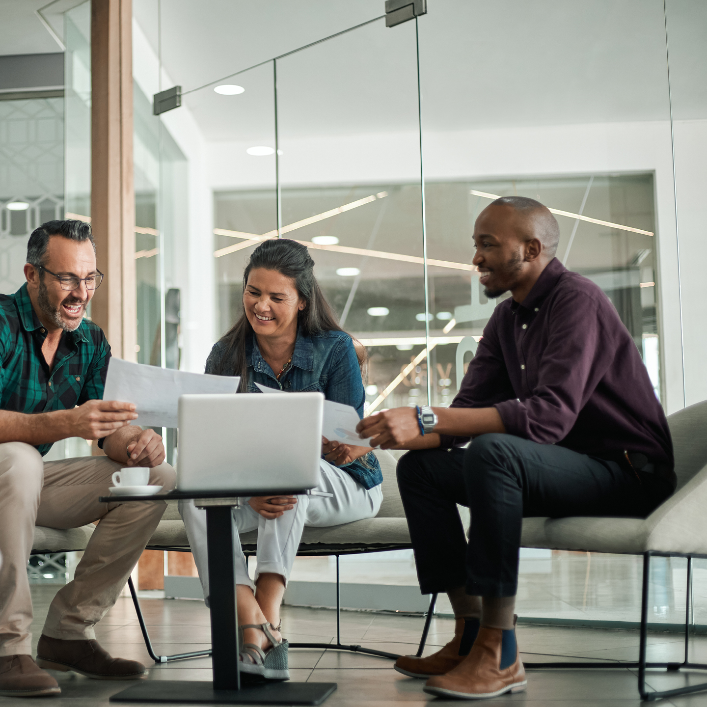 Colleagues reviewing content on paper and laptop in shared office setting