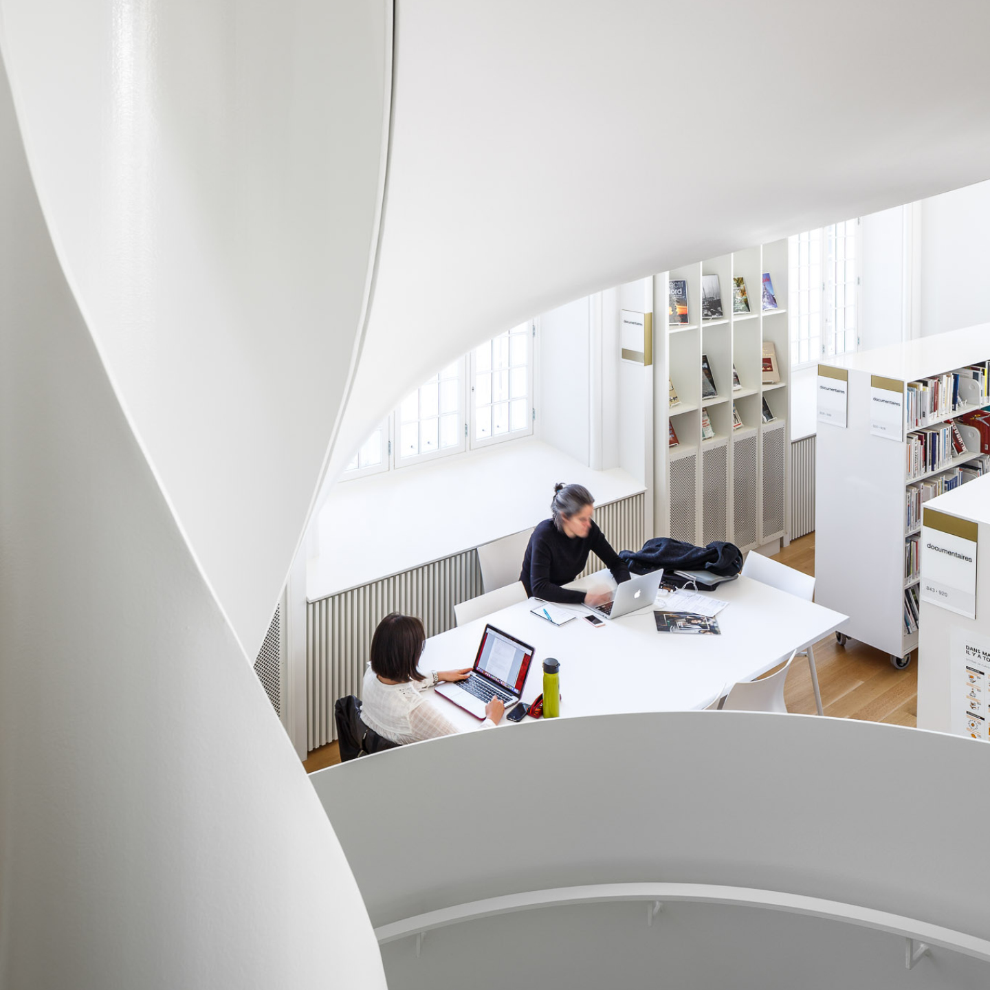 People on working on laptops in a library setting