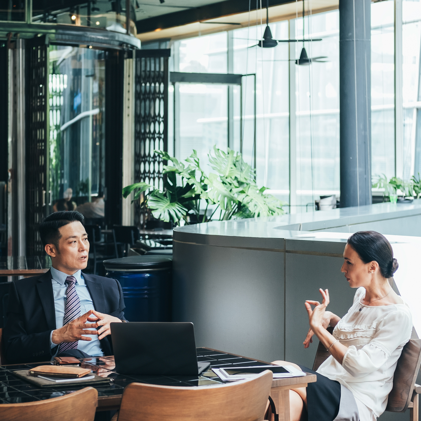 Business people in discussion around a table in open office setting
