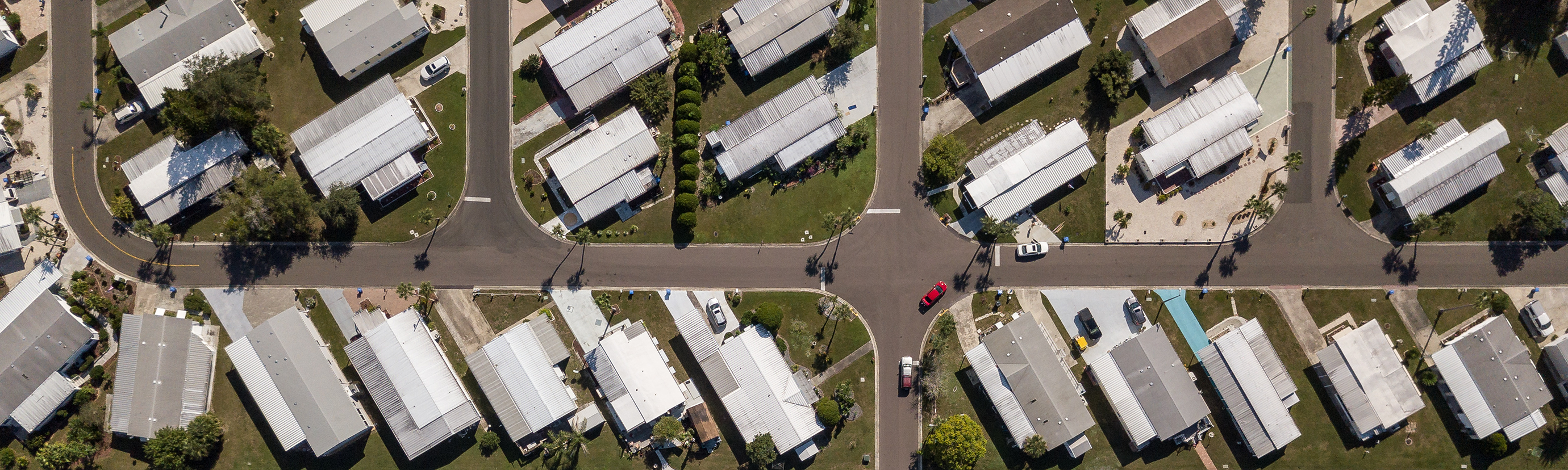 Aerial view of a manufactured housing community with neatly arranged homes and streets, showcasing the organized layout and density of affordable housing options