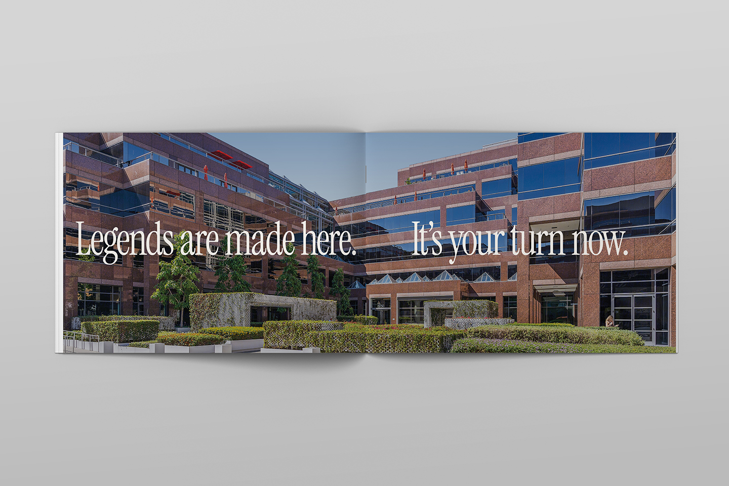 Modern brick office building with landscaped courtyard and text "Legends are made here"