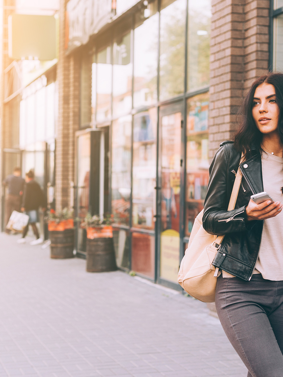 Female walking down a sidewalk full of retail
