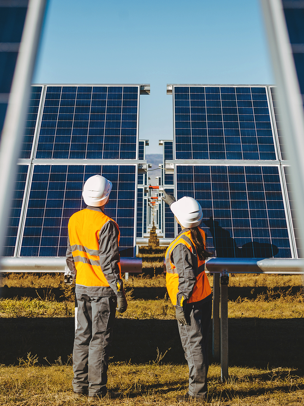 workers examining solar panels