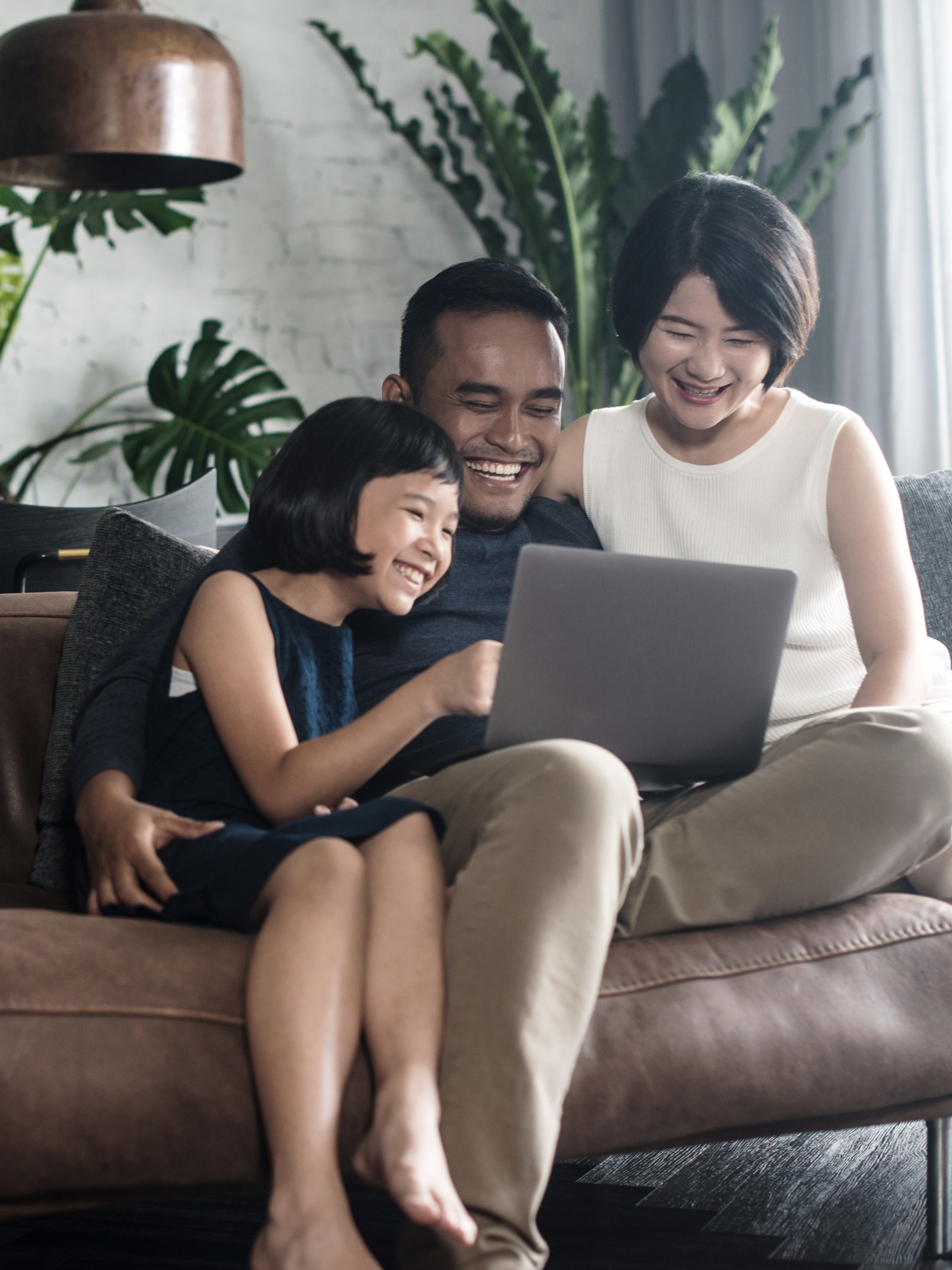 Family sitting on couch looking at computer