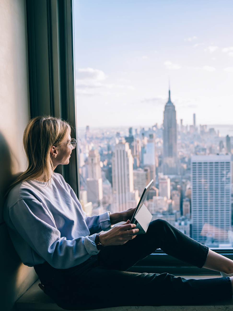 office professional works by window of office high rise