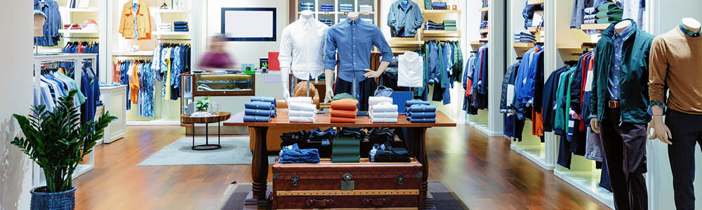 Image of a well-organized and upscale men's clothing store interior, showcasing neatly arranged clothing and mannequins.