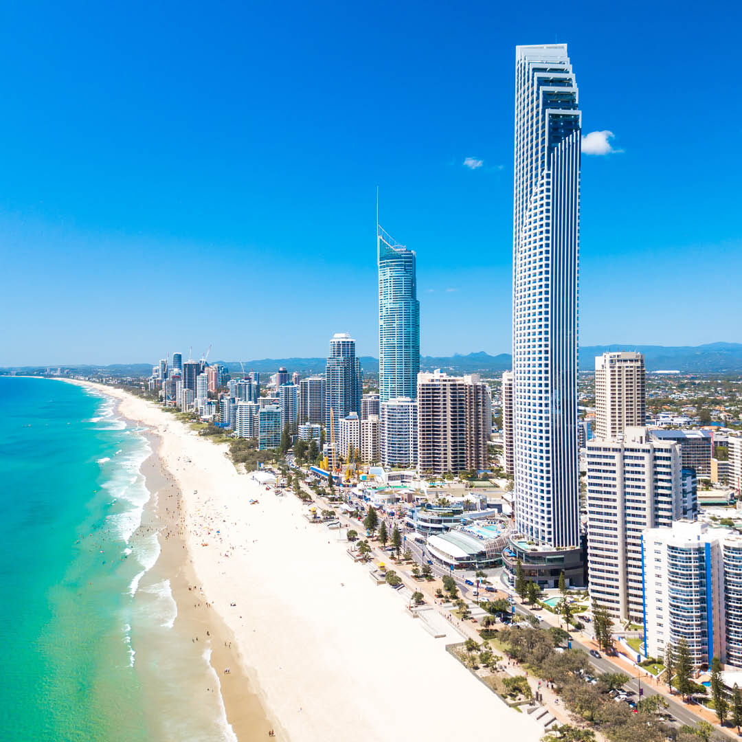 Aerial view of beachfront high-rise buildings and luxury hotels in a coastal city.  Ideal for commercial real estate investment.
