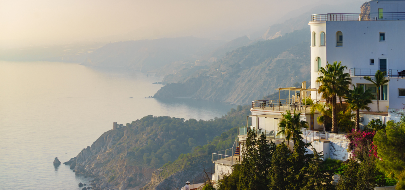 White villa on a cliff overlooking the sea.