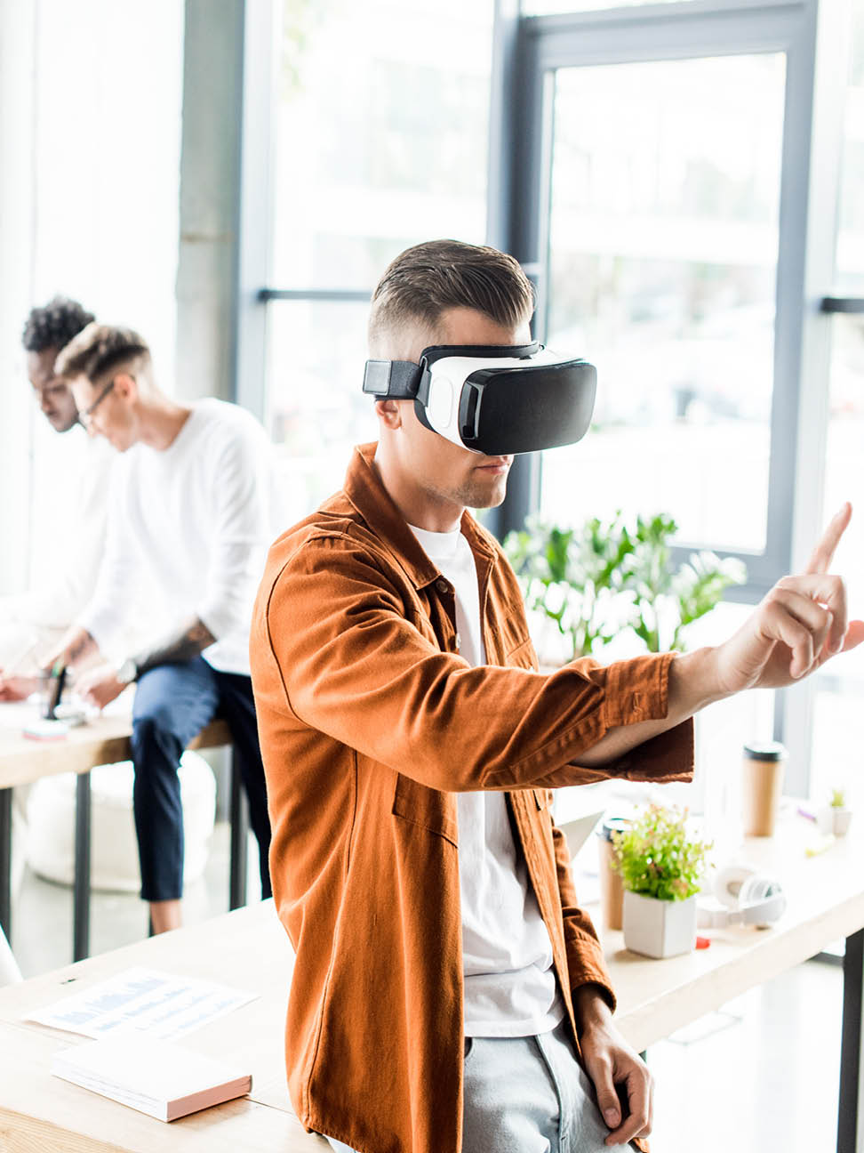 person using a VR headset with other employees working in the background