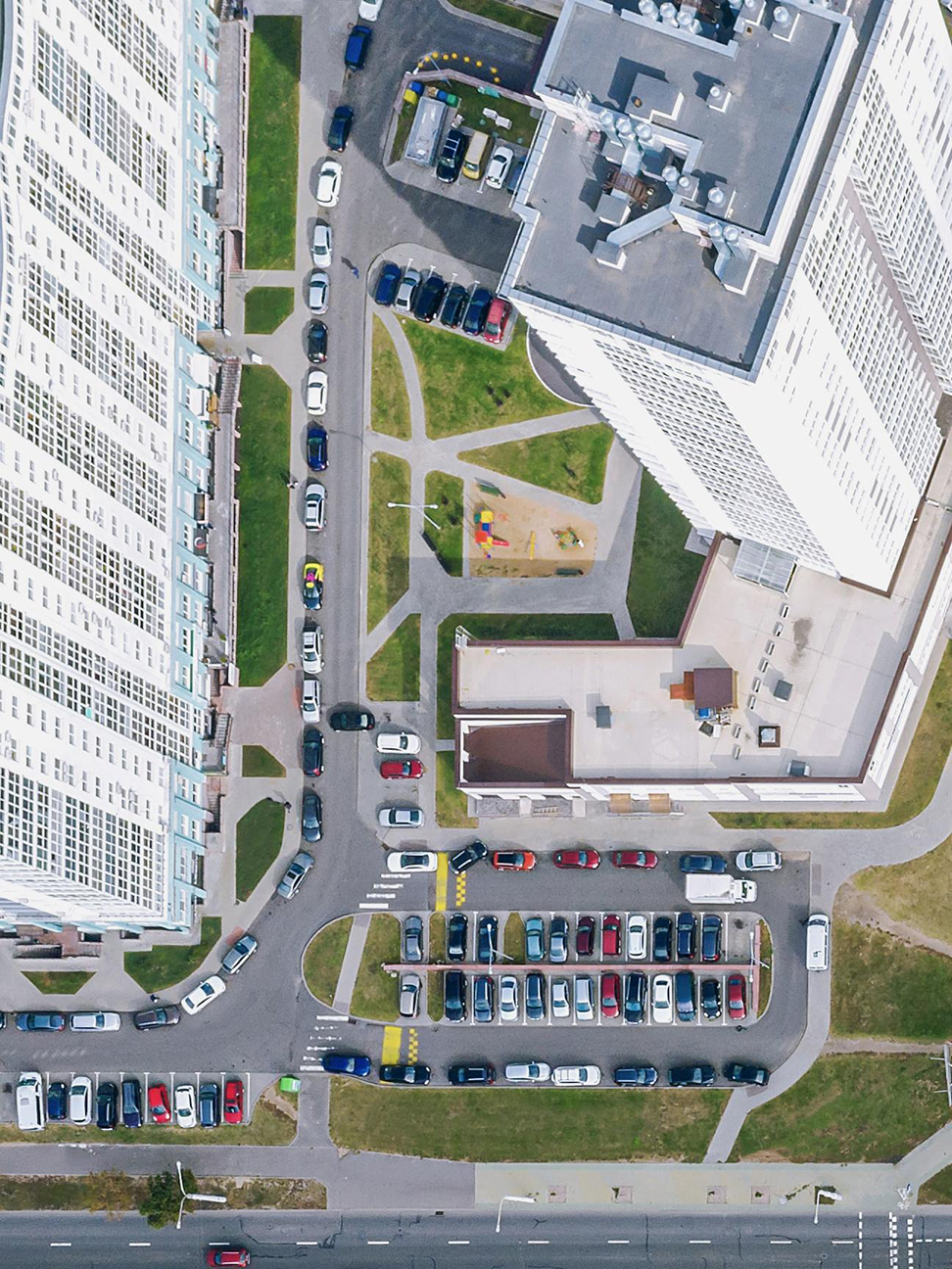 Aerial view of cars parked in lots and streets between buildings