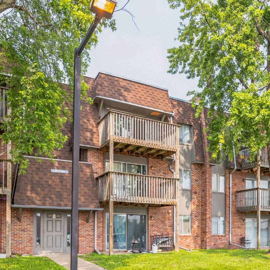 A light brown brick apartment building on a sunny day