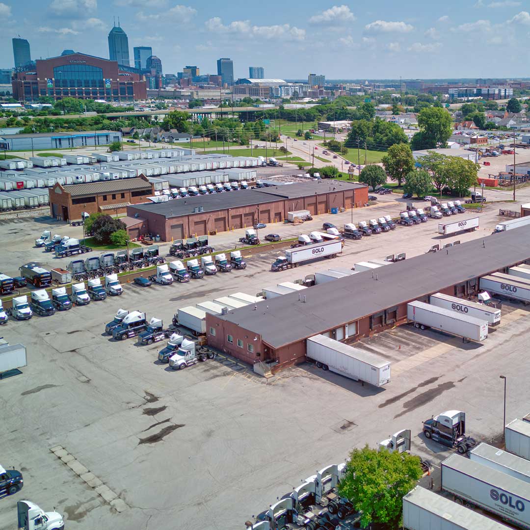 A spacious parking lot filled with parked trucks under a clear blue sky.