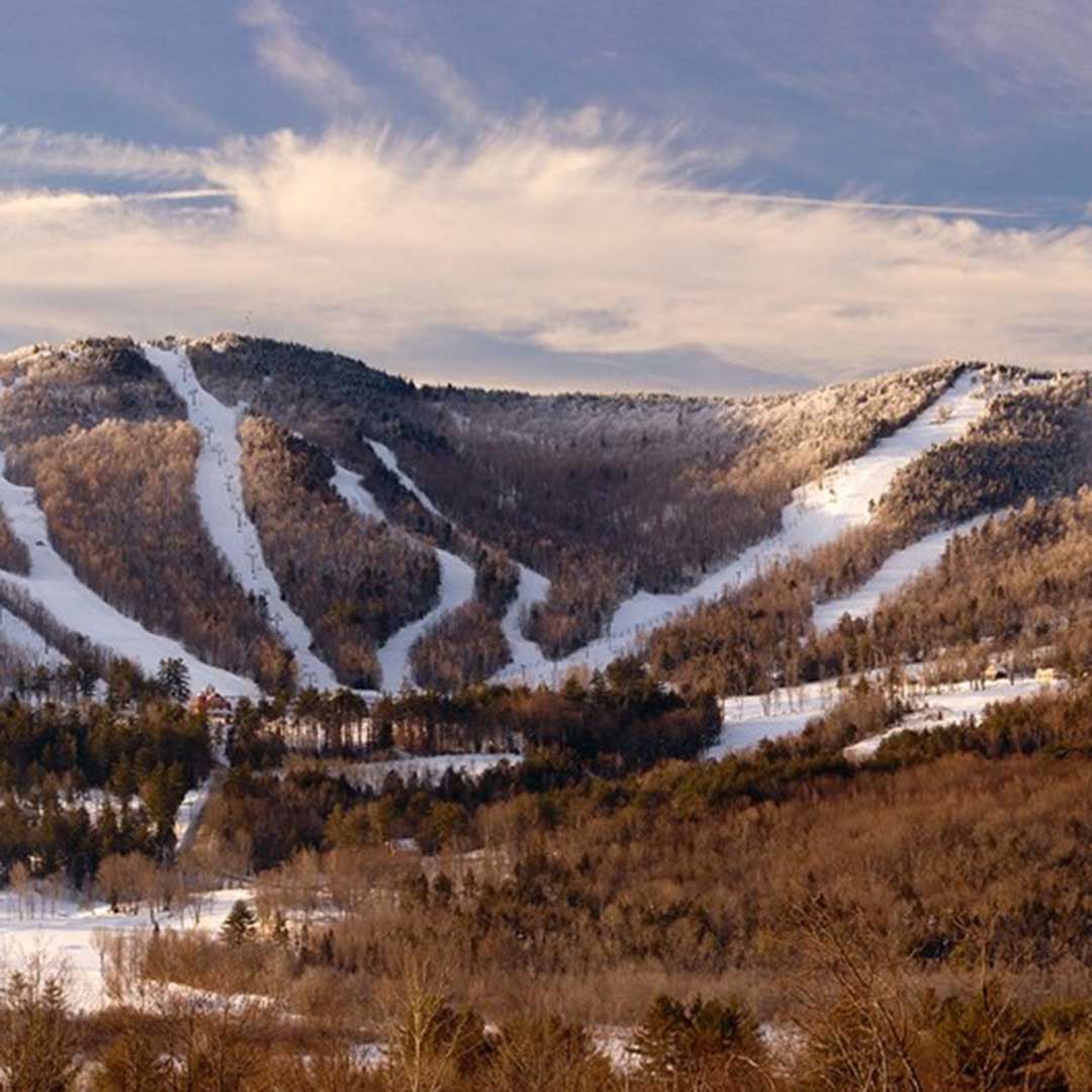A snowy ski slope surrounded by trees, showcasing a winter landscape ideal for skiing and outdoor activities.
