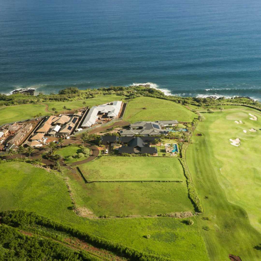 Aerial view showcasing a lush golf course bordered by a serene ocean, highlighting the beauty of nature and recreation.