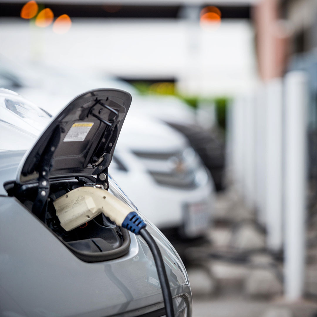Electric vehicle charging in a car park, showcasing our EV charging solutions for sustainable transportation.