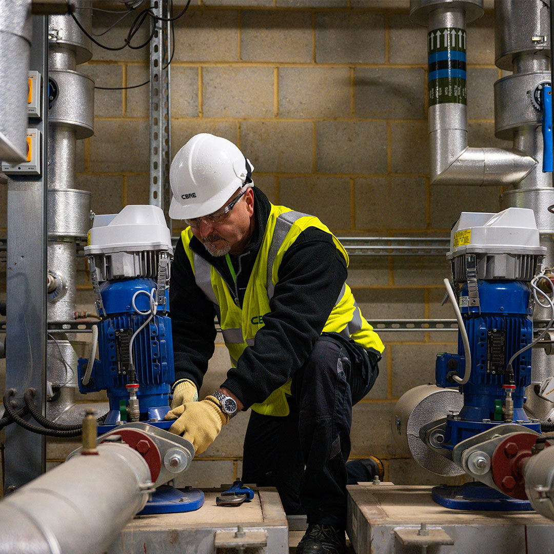 CBRE technician installing an energy-efficient HVAC system, optimizing resources for sustainable building operations.